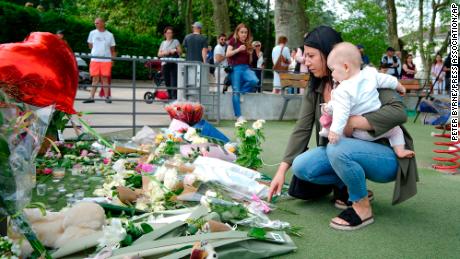 People lay flowers near the scene at a lakeside park in Annecy, France, on Friday, after a knife attack left four children and two adults wounded.