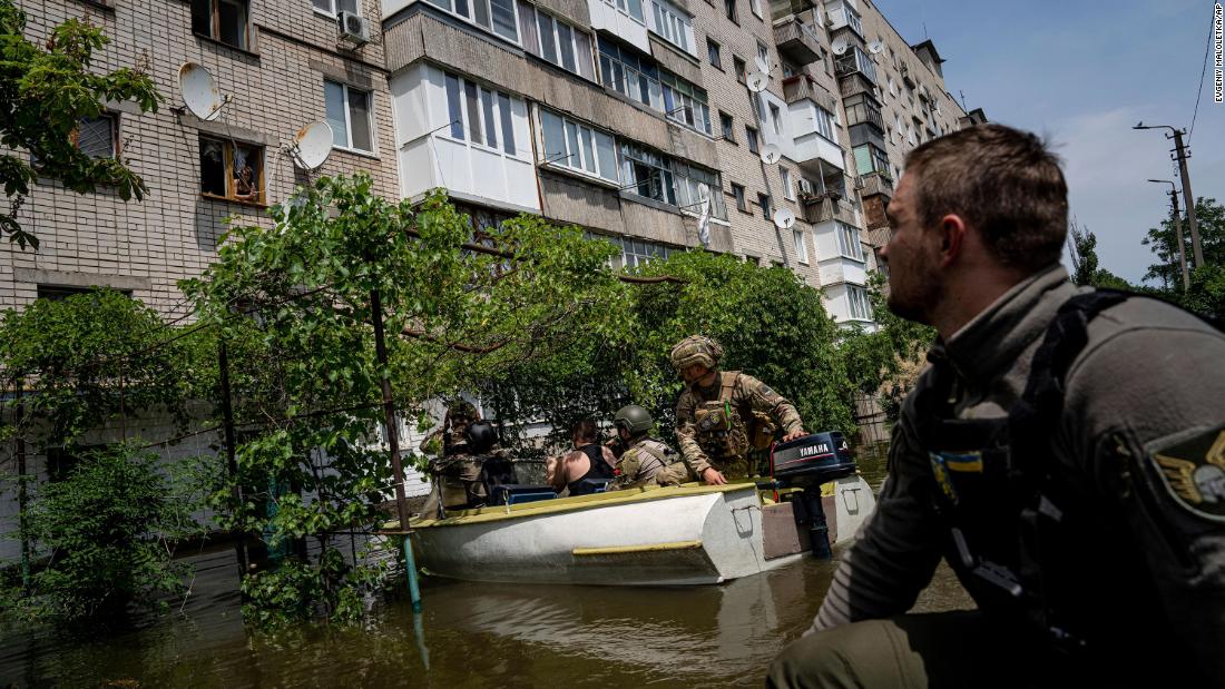 Ukrainian servicemen use boats to evacuate people in a flooded neighborhood of Kherson on June 8.