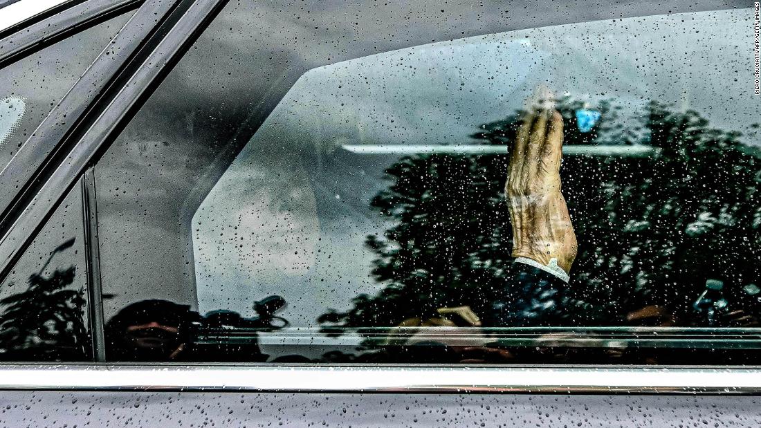 Berlusconi waves from inside a car after being discharged from a hospital in Milan on May 19.