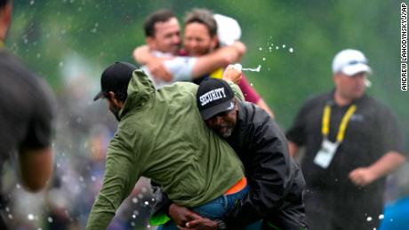 Canadian golfer Adam Hadwin, left, is tackled by a security guard when he tries to celebrate with compatriot Nick Taylor, background left, after Taylor won the Canadian Open in Toronto on Sunday.
