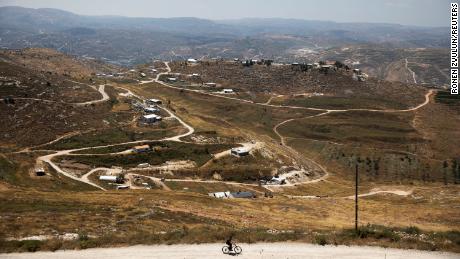 A youth rides a bicycle on a road in the Jewish settlement of Yitzhar, in the occupied West Bank, in June 2020.