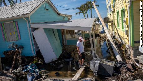 A man stands in front of his destroyed house in the aftermath of Hurricane Ian in Matlacha, Florida, on October 3, 2022.