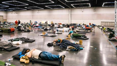 People rest at the Oregon Convention Center cooling station in Oregon, Portland on June 28, 2021, during the searing heat wave.