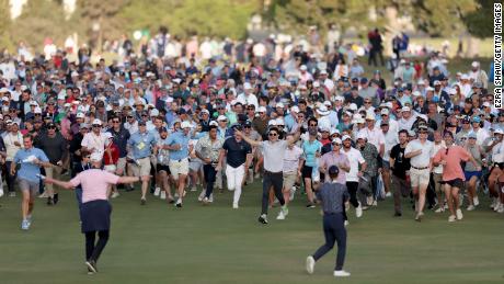 Crowds spill onto the 18th fairway to watch the closing stages.
