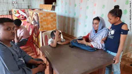 Sabah Ahmed (center right) sits in a cafe with her sons Mohamed, Zeyazen and Kareem and daughter, Renad, while they wait to be interviewed at the US embassy in Khartoum on March 9, 2023.