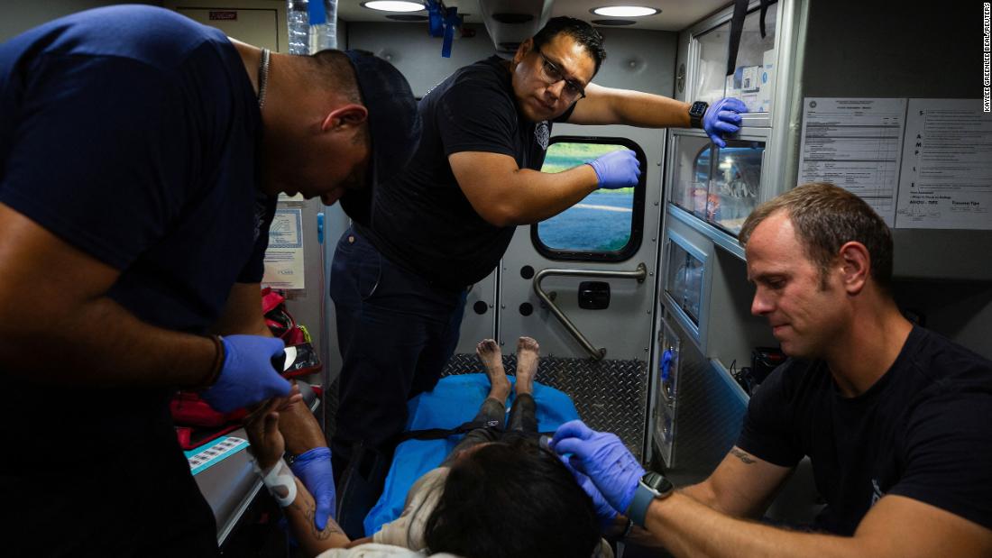 EMTs treat a woman who was suffering from heat exhaustion in Eagle Pass. She recovered with their help, according to the Reuters news agency.