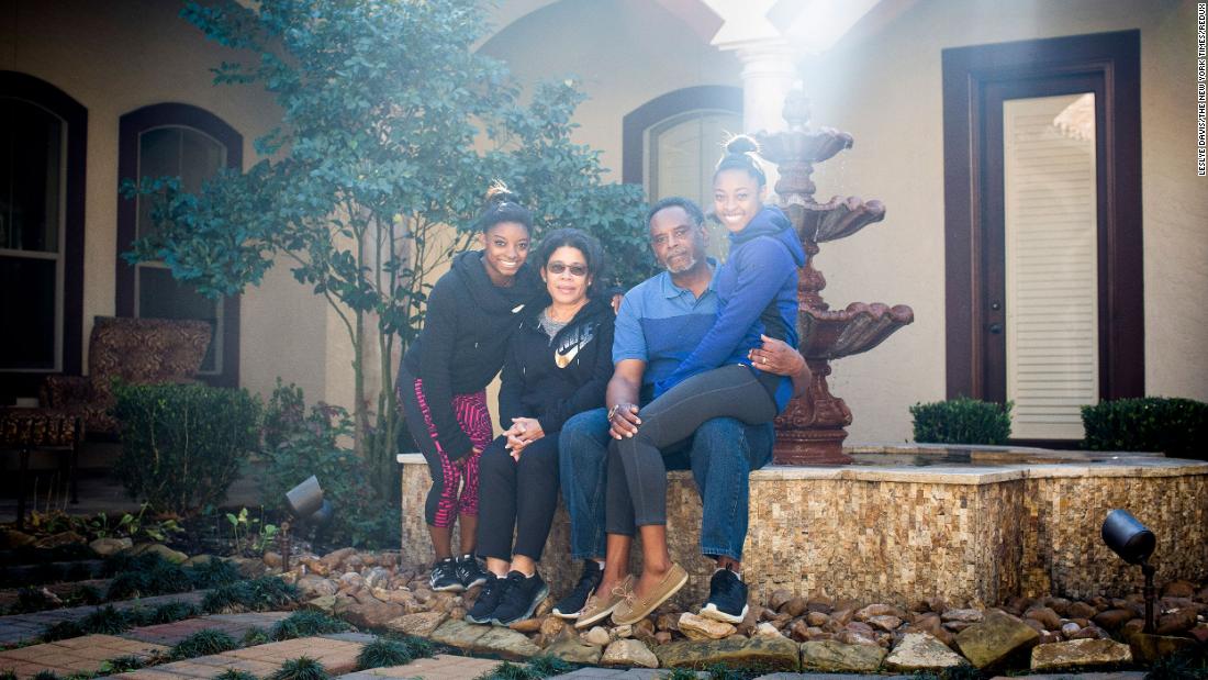 Biles, left, poses at home with her grandparents Ron and Nellie, who adopted her and her younger sister Adria, right.