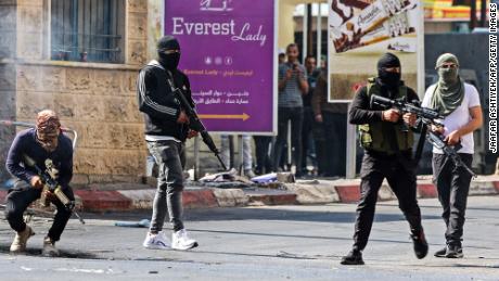 Palestinian armed militants take up positions during a clash with Israeli forces in Jenin on Monday.