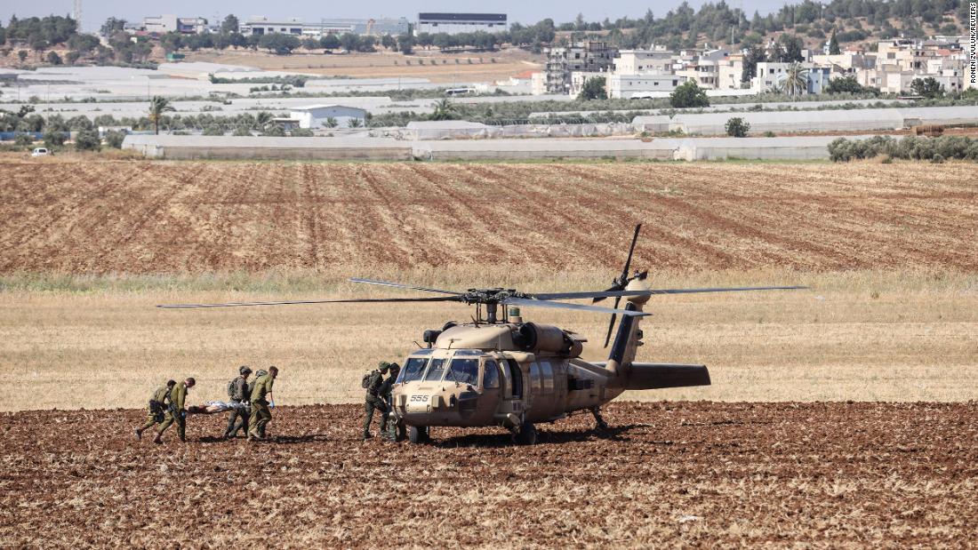 Israeli military carry a wounded person to a helicopter on Monday.
