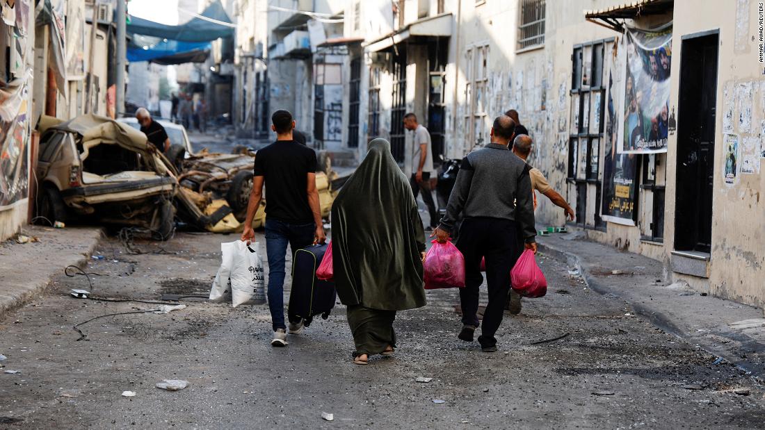 People carry their belongings on the street Wednesday after the Israeli army&#39;s withdrawal from the Jenin refugee camp.