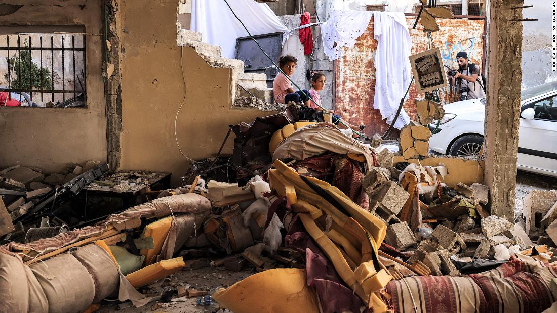 Children sit by rubble and broken furniture at a damaged building in Jenin on Wednesday.