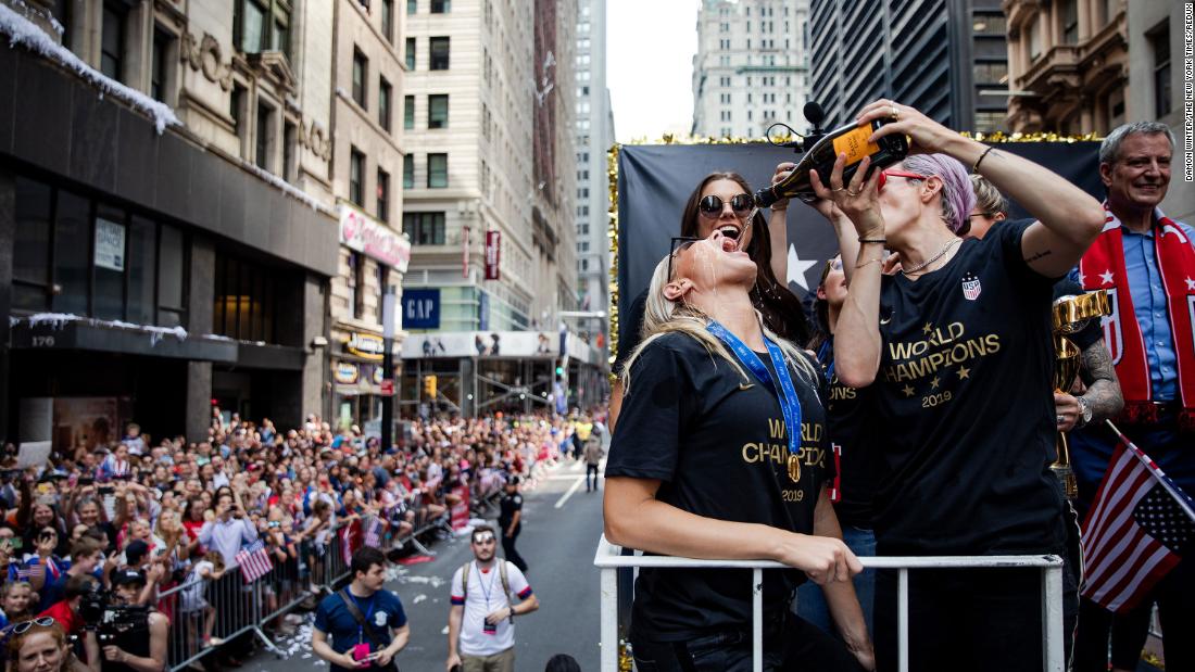 Rapinoe, right, pours champagne into Allie Long&#39;s mouth during a ticker-tape parade in New York to commemorate the Americans&#39; World Cup victory in July 2019.