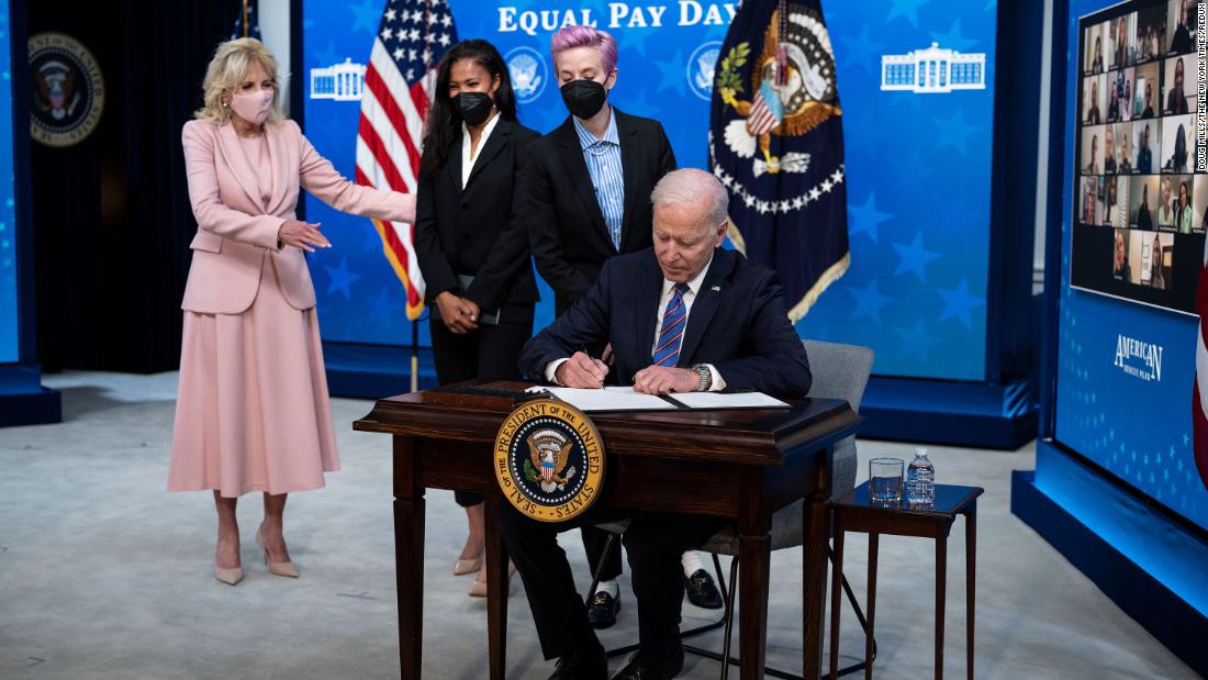 From left, first lady Jill Biden, American soccer player Margaret Purce and Rapinoe watch US President Joe Biden sign a proclamation declaring March 24, 2021, as National Equal Pay Day during an event in Washington, DC.
