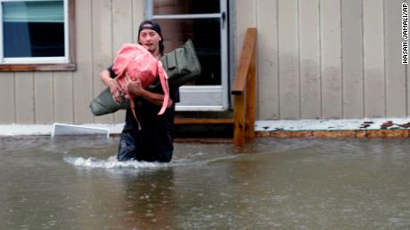 A man carries belongings through floodwaters from a home in Bridgewater, Vermont, on Monday. 