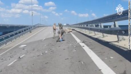 Russian investigators work at the scene on the section of the bridge damaged on July 17, 2023.