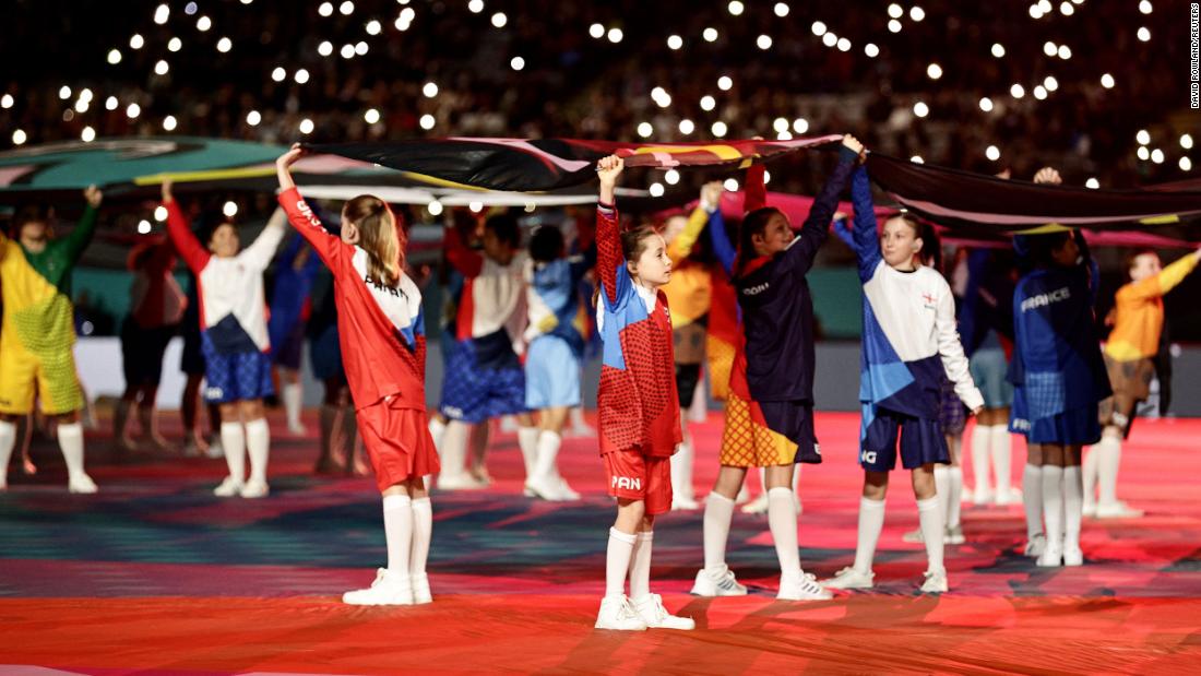 Children hold flags during the opening ceremony.