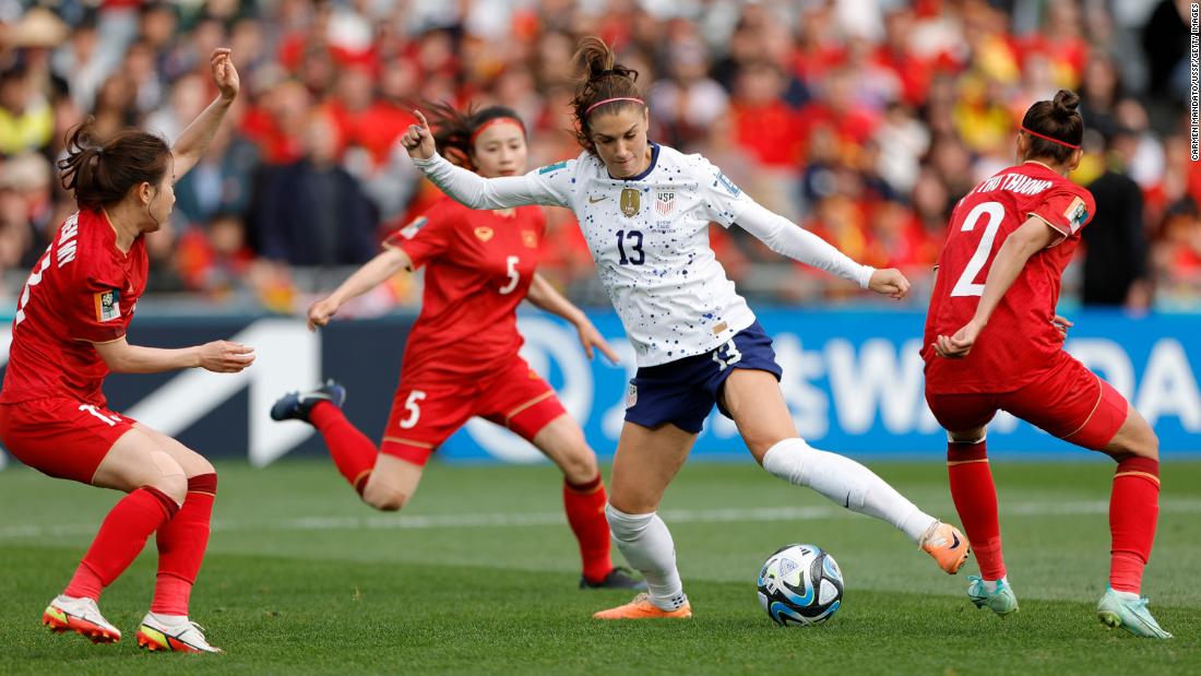 US forward Alex Morgan is surrounded by Vietnam defenders during their opening match on July 22. The United States, the two-time defending champs, won 3-0.