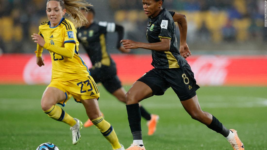 South Africa&#39;s Hildah Magaia, who scored the opening goal, runs with the ball alongside Sweden&#39;s Elin Rubensson.