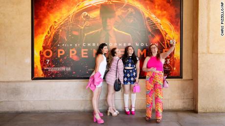 From left, Gabrielle Roitman, Kayla Seffing, Maddy Hiller and Casey Myer take a selfie in front of an &quot;Oppenheimer&quot; movie poster before they attended an advance screening of &quot;Barbie&quot; on Thursday in Los Angeles. 