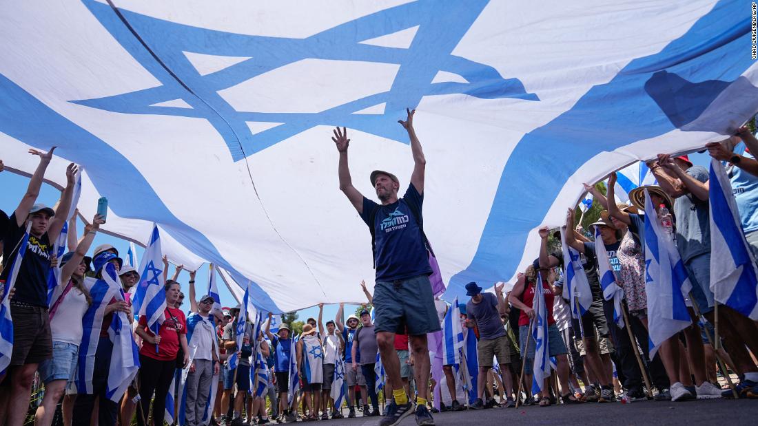 Demonstrators wave a large Israeli flag during a protest outside the Knesset on July 24.