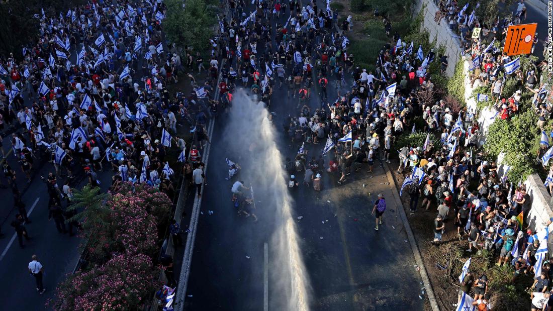 Israeli security forces use a water cannon to disperse protesters blocking the entrance of the Knesset on July 24.