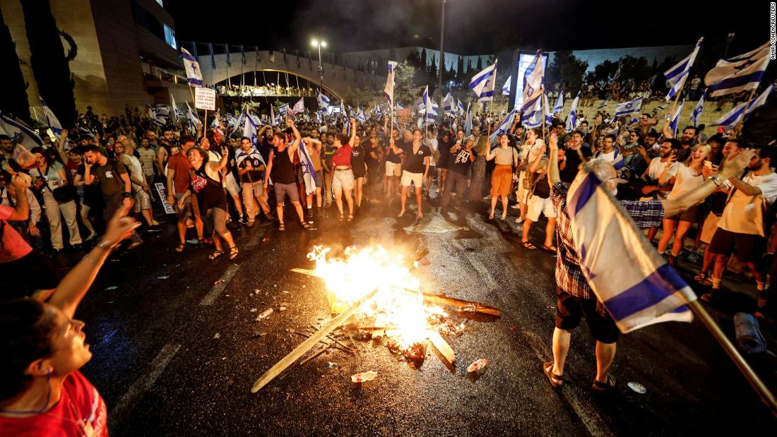 Protesters demonstrate around a fire near the Knesset in Jerusalem, on Monday, July 24.