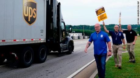 A UPS truck drives by as Teamsters President Sean O&#39;Brien, left, and union members at a rally Friday in Atlanta.