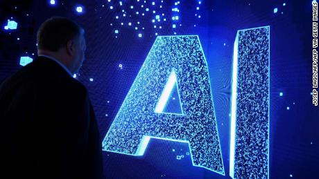 A visitor watches an AI (Artificial Intelligence) sign on an animated screen at the Mobile World Congress (MWC), the telecom industry&#39;s biggest annual gathering, in Barcelona. (Photo by Josep LAGO / AFP) (Photo by JOSEP LAGO/AFP via Getty Images)