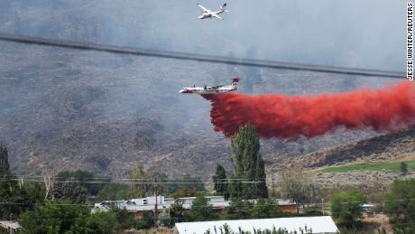 An air tanker drops fire retardant on the Eagle Bluff wildfire after it crossed the Canada-US border from the state of Washington and prompted evacuation orders in Osoyoos, British Columbia, Canada, July 30, 2023.
