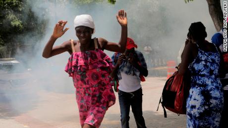 Haitians flee tear gas fired by officers clearing a camp of people at the US embassy seeking to escape the violence of armed gangs on July 25. 