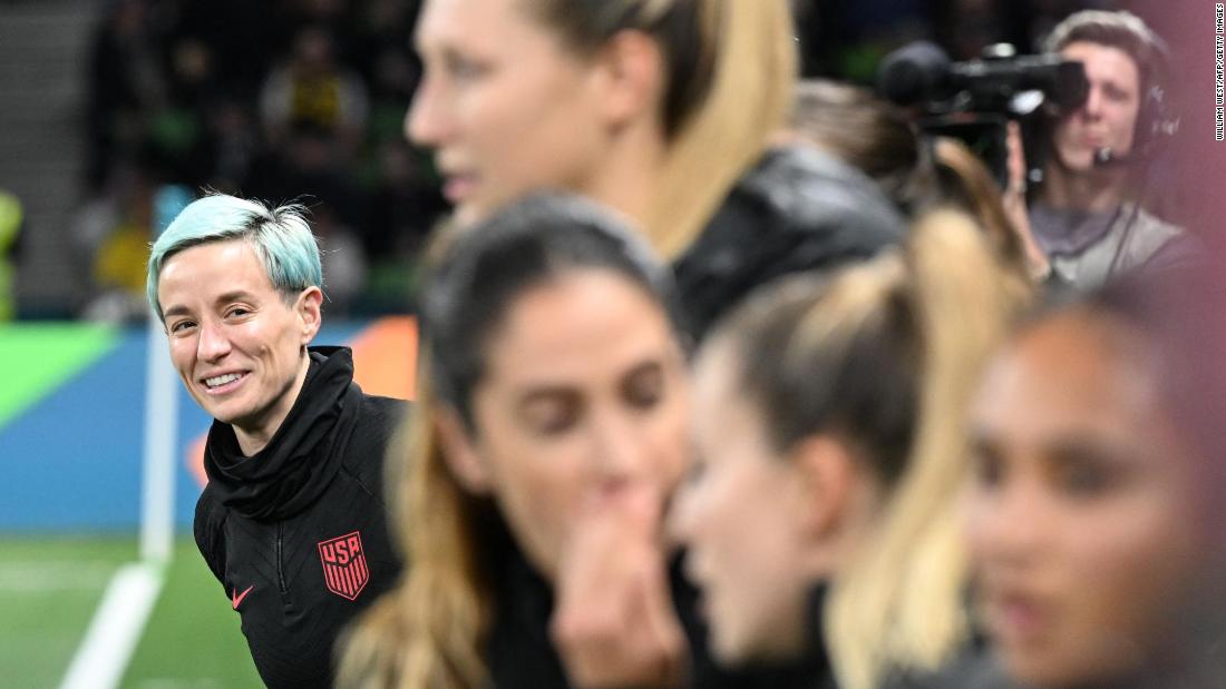 Rapinoe, left, looks on from the substitutes&#39; bench. 