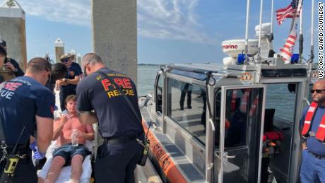 Charles Gregory receives care from EMS after being rescued a dozen miles off Florida&#39;s coast on Saturday.