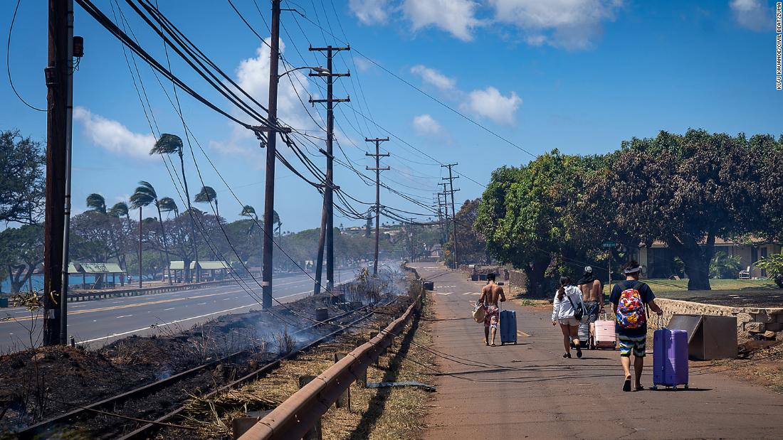 Residents carry their belongings after wildfires swept through Lahaina on August 9.