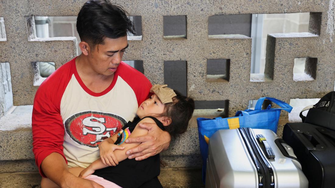 Vixay Phonxaylinkham holds his 4-year-old child Lana while they wait for their flight at the Kahului Airport on August 10. Phonoxaylinkham, his wife and their five children were heading back to California. They had been caught in the wildfires, but they survived by spending four hours in the ocean.