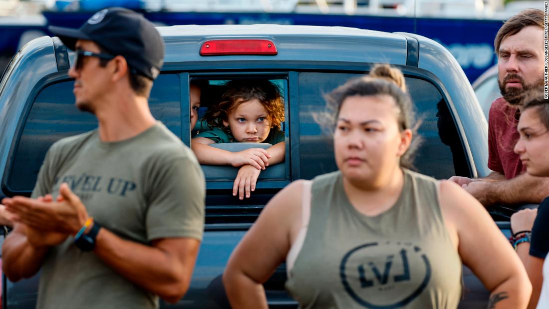 Volunteers in Maalaea, Hawaii, watch truckloads of donated food and supplies depart for Lahaina on Thursday, August 10.