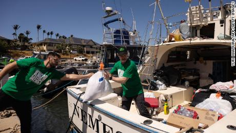 Volunteers in Maalaea, Hawaii, on August 12, 2023, load a boat with supplies to deliver to West Maui towns affected by wildfires. 
