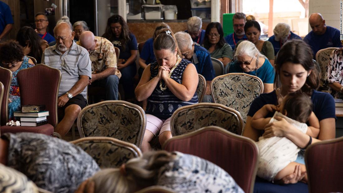 People pray during a church service in Wailuku on August 13. The Maui Coffee Attic opened up space for the service after a wildfire destroyed Lahaina&#39;s Grace Baptist Church.