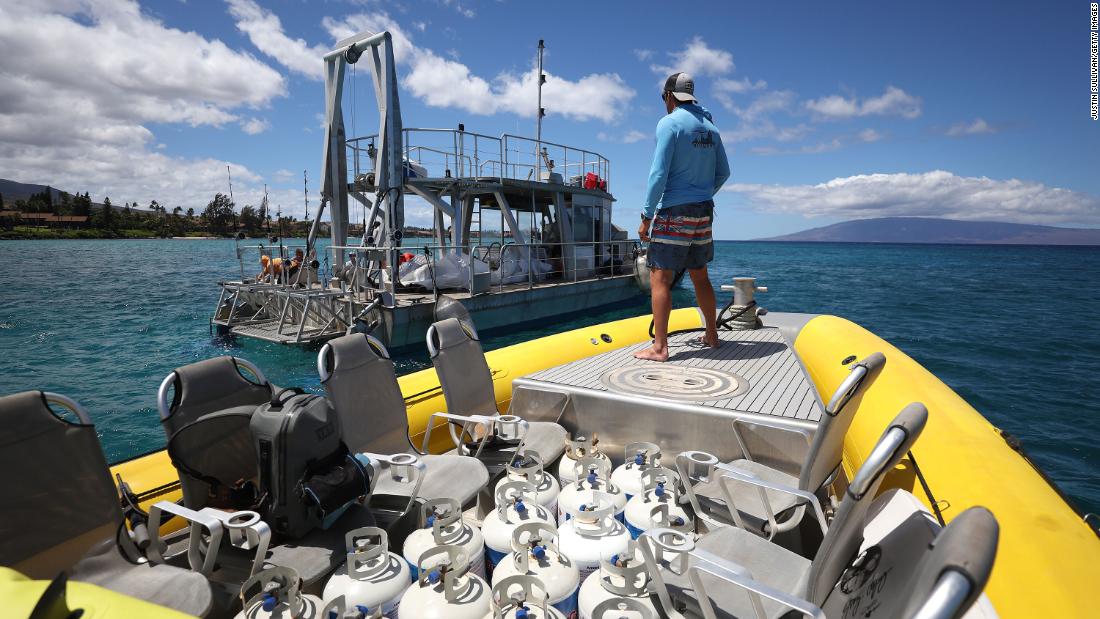 A volunteer prepares to dock next to a fishing boat to transfer propane tanks that would be ferried to shore in Kaanapali, Hawaii, on August 14.