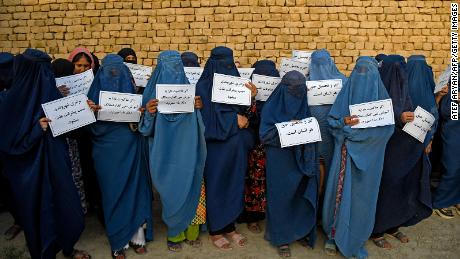 Afghan women wearing a burqa hold placards as they protest for their right to education, in Mazar-i-Sharif on August 12, 2023. 