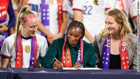 Crystal Dunn (middle) signs a collective bargaining agreement signing signifying equal pay between the US men&#39;s and women&#39;s national soccer teams on September 6, 2022 in Washington, DC. 