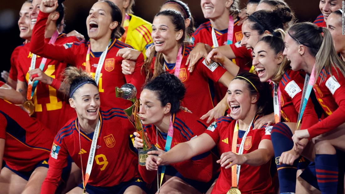 Spanish players celebrate with the trophy during the post-match award ceremony.