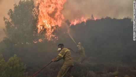 Firefighters battle flames during a wildfire near Prodromos on August 21, 2023. 
