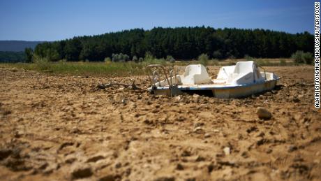 A paddleboat lies in the mud of the Montbel&#39;s lakebed, on August 18, 2023. Montbel is well below its normal level due to an unprecedented drought.