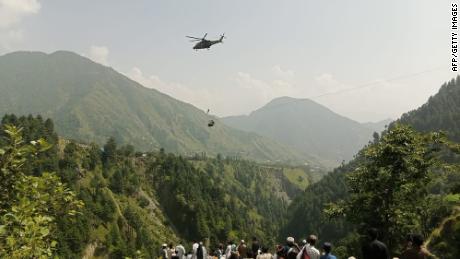 Six children and two adults are in the chairlift suspended over a deep valley in Pakistan.