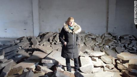 Debra Brunner of The Together Plan stands in a warehouse in Brest, surrounded by the broken headstones.