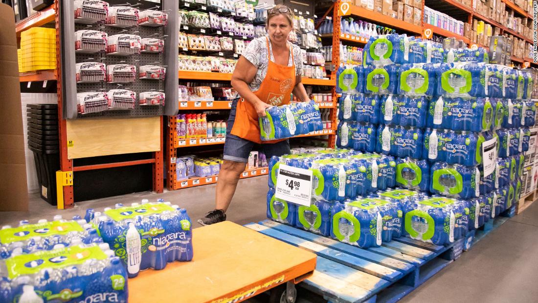 Home Depot employee Sharon Walsh fills a cart with cases of water as customers prepare for Idalia in Ocala, Florida, on August 28.
