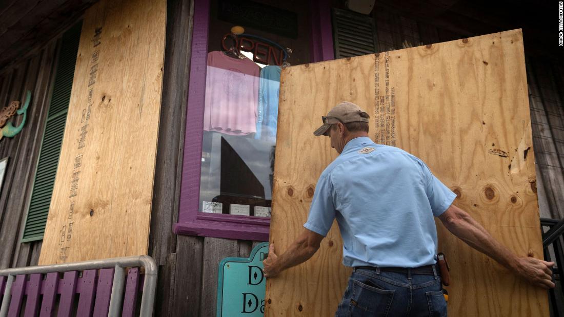 A man places plywood in front of a store in Cedar Key as he prepares for Hurricane Idalia on August 29.