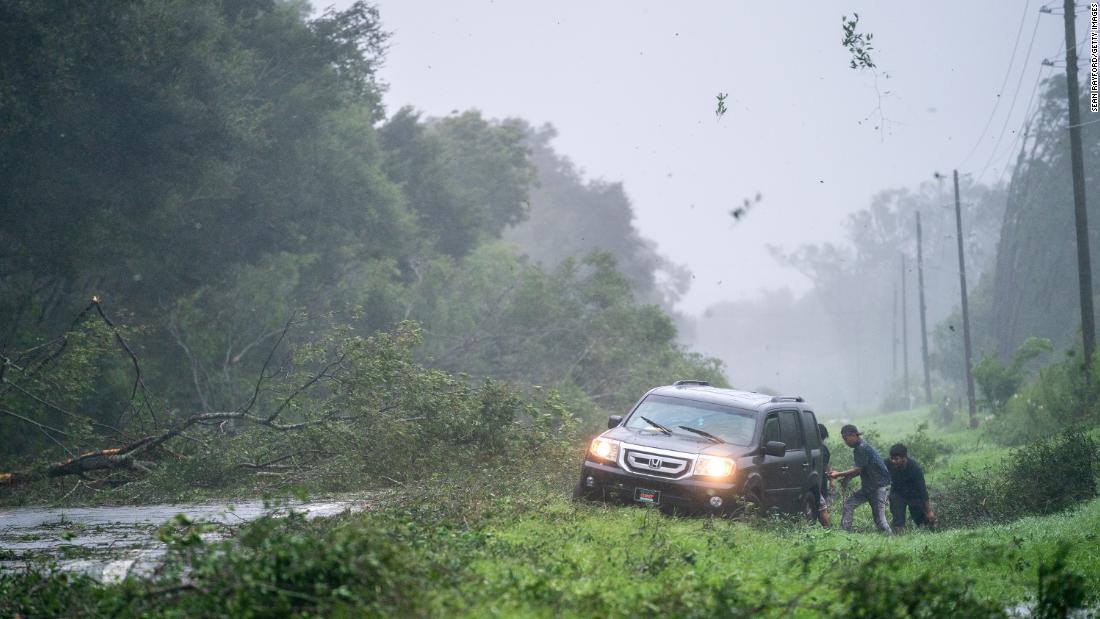 People work to free a vehicle that was stuck in storm debris near Mayo, Florida, on August 30.