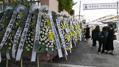 Mourners pass funeral wreaths in front of an elementary school in Seoul on September 4, following the apparent suicide of a teacher in July.