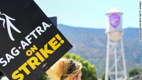 Members of the Writers Guild of America and the Screen Actors Guild walk a picket line outside of Warner Bros Studio in Burbank, California, on July 26, 2023. Tens of thousands of Hollywood actors went on strike at midnight July 14, 2023, effectively bringing the giant movie and television business to a halt as they join writers in the first industry-wide walkout for 63 years. 